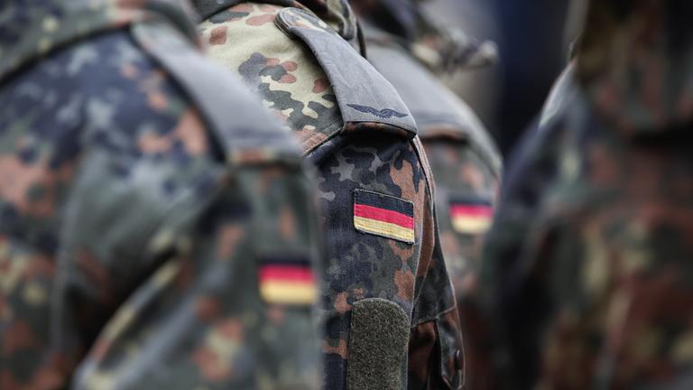 Eine Reihe von Soldaten trägt Deutschlandflaggen auf ihrer Uniform am 19.11.2025 in Mainz.