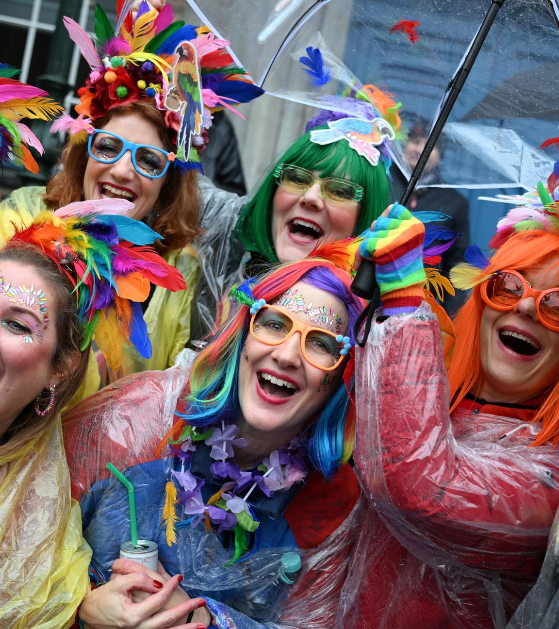 Weiberfastnacht, Nordrhein-Westfalen, Düsseldorf: Jeckinnen stehen vor dem Rathaus im Regen.