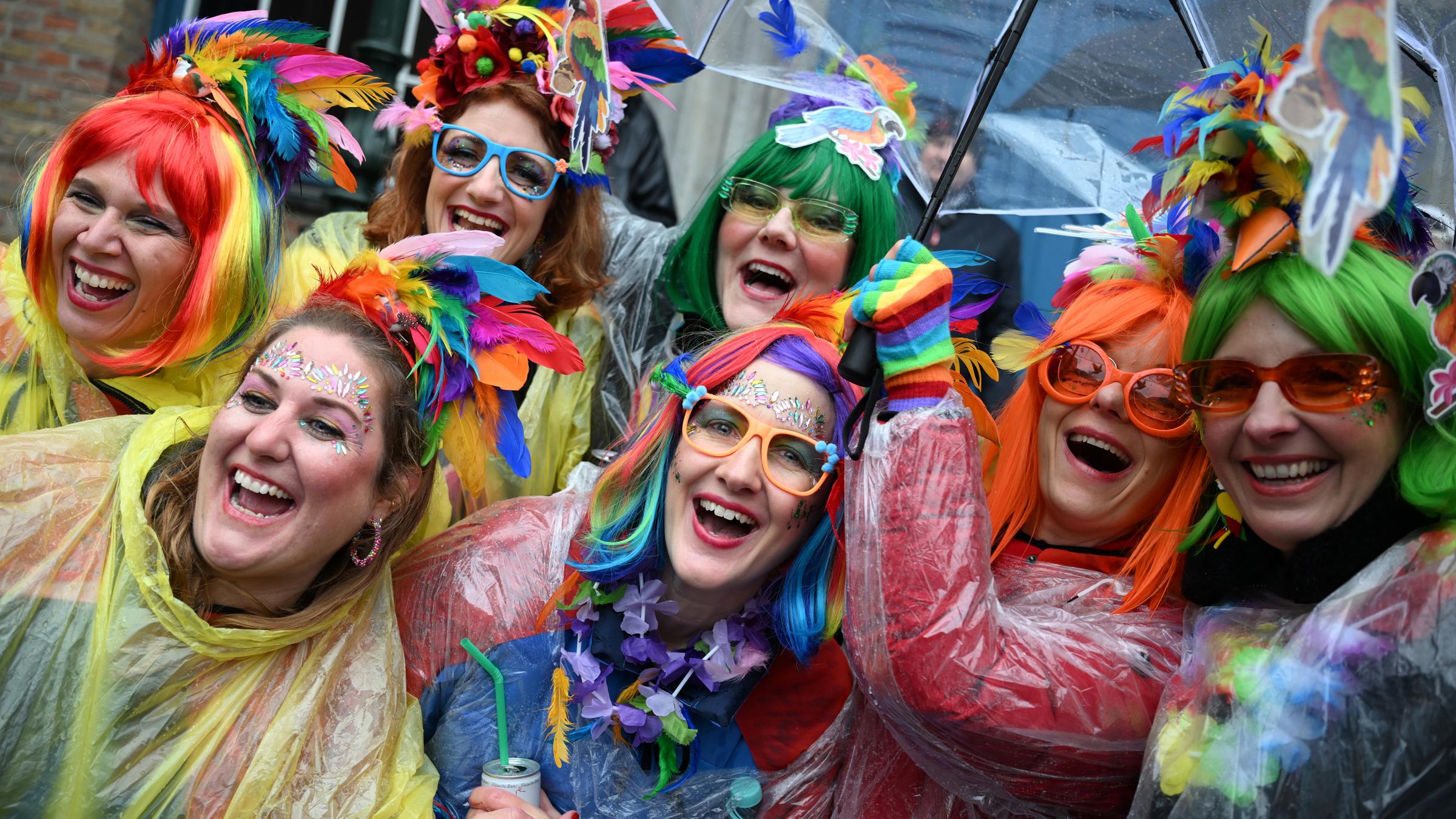 Weiberfastnacht, Nordrhein-Westfalen, Düsseldorf: Jeckinnen stehen vor dem Rathaus im Regen.