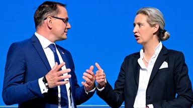 Tino Chrupala links & Alice Weidel rechts vor blauem Hintergrund auf dem AfD-Bundesparteitag, beide schauen sich an
