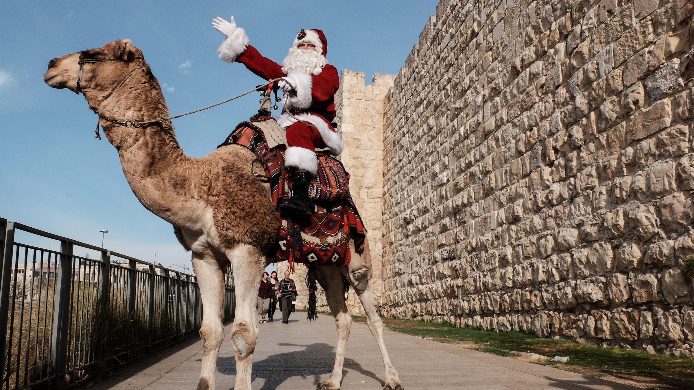 Ein als Weihnachtsmann verkleideter Mann reitet am 21.12.2017 in Jerusalem auf einem Kamel