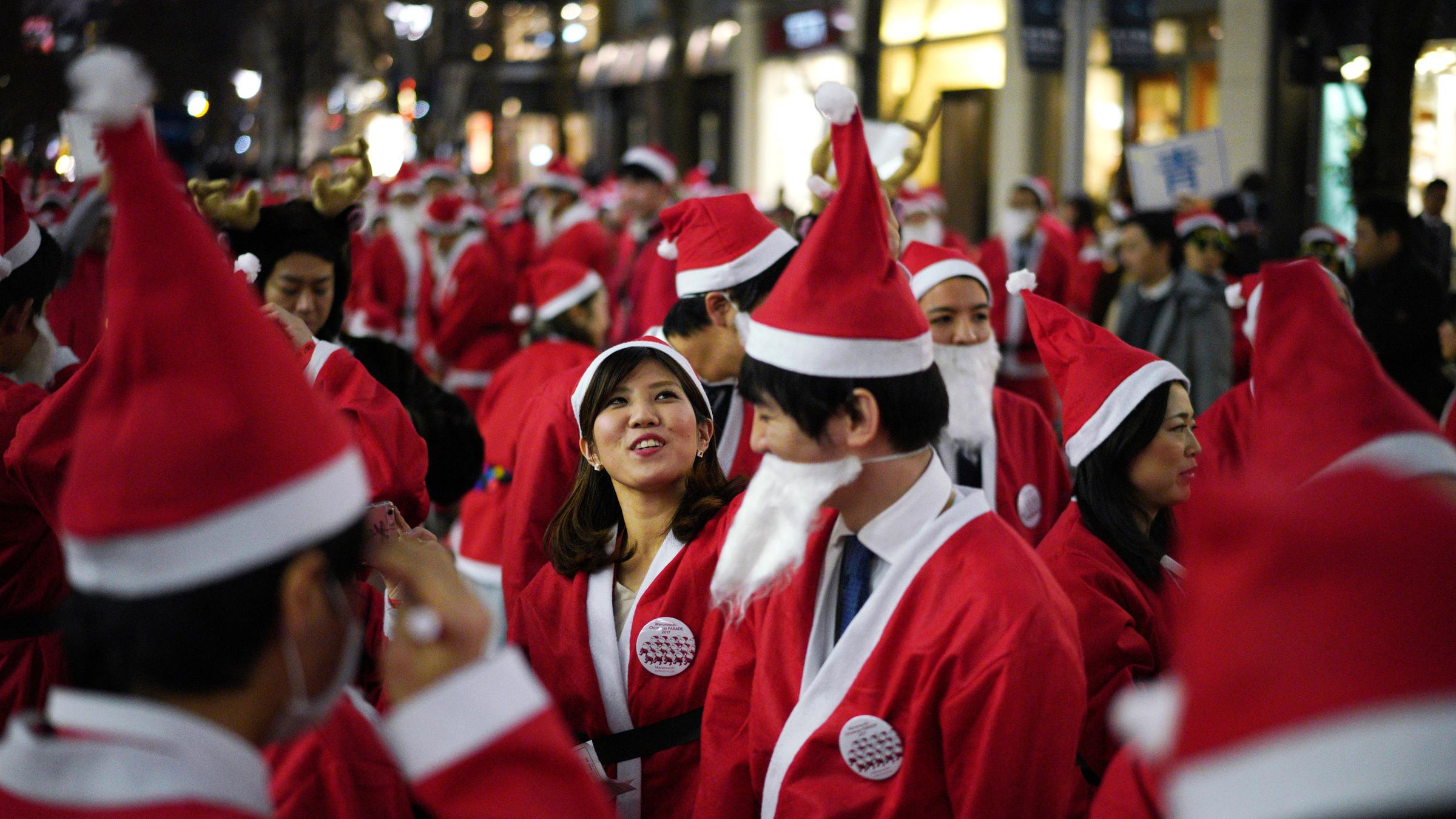 Als Weihnachtsmänner verkleidete Arbeiter feiern am 22.12.2017 im Marunouchi Bezirk in Tokio (Japan)
