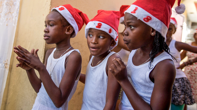 Drei Mädchen stehen am 22.12.2017 in Port-au-Prince (Haiti) während einer Weihnachtsveranstaltung hinter einer Bühne