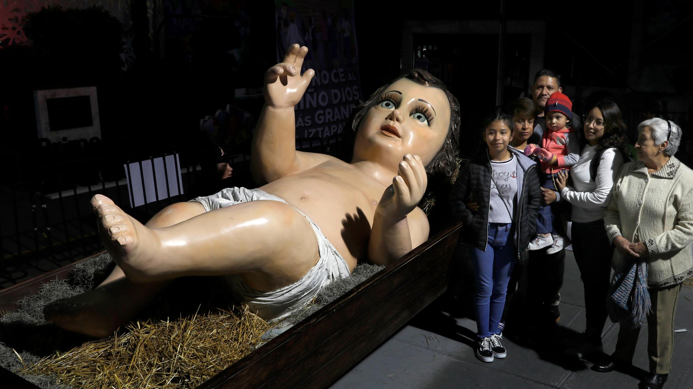 Jesuskind-Statue und Passanten