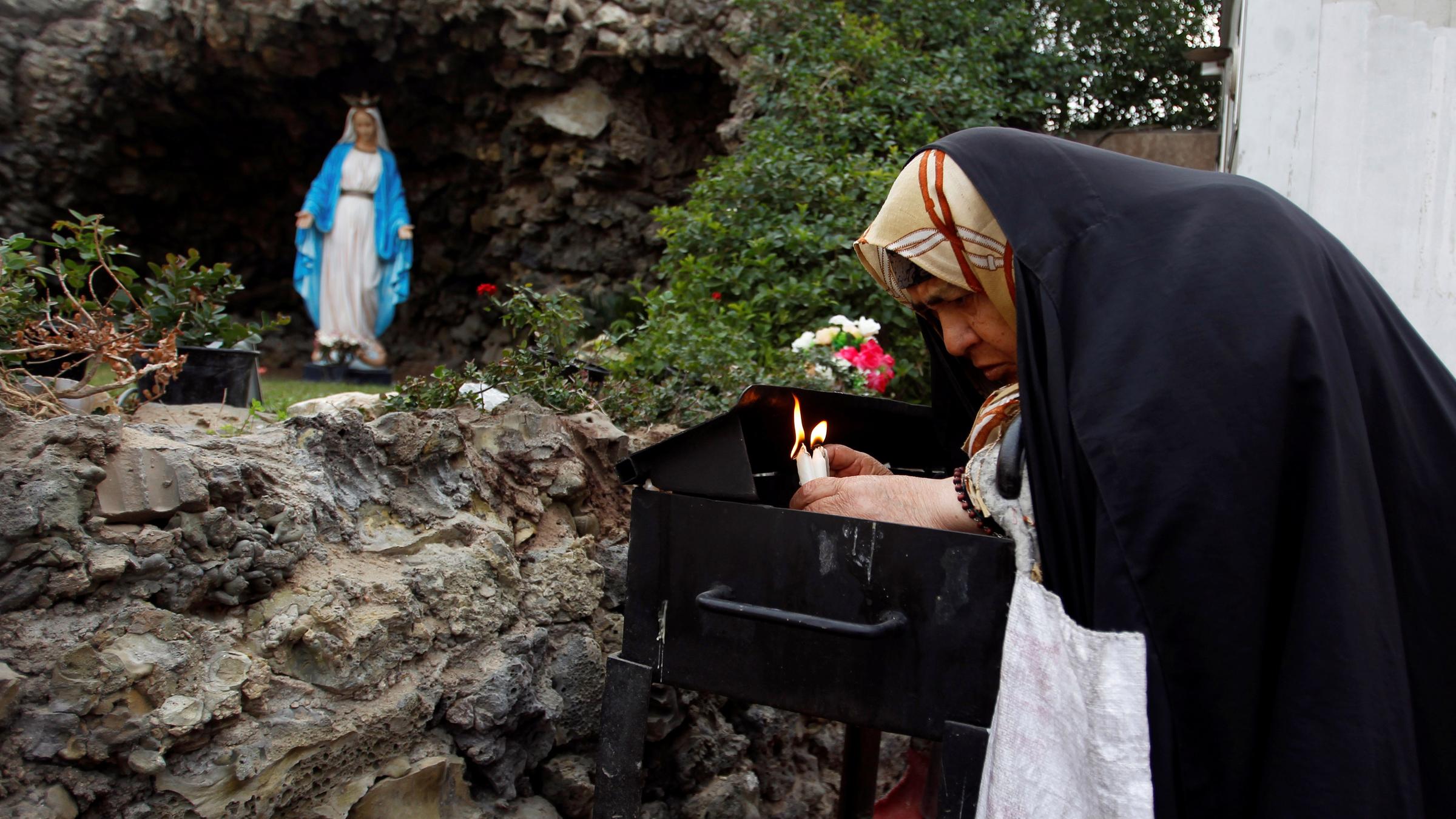 Frau zündet Kerzen an
