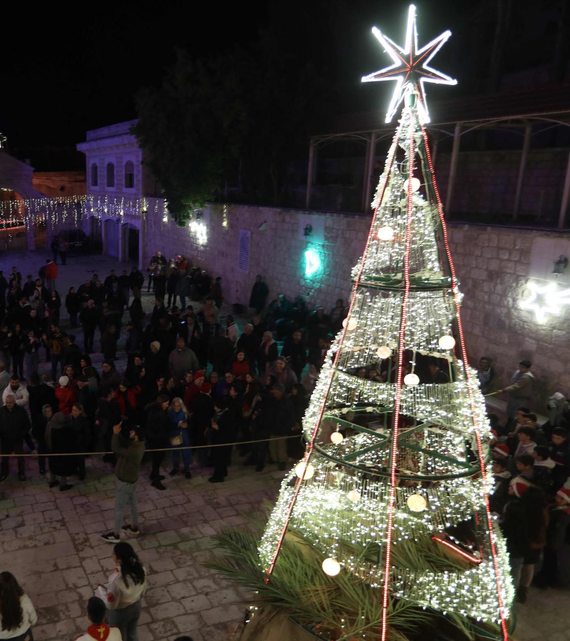 Bewohner versammeln sich am 20. Dezember 2025 in dem überwiegend christlichen Dorf Al-Qanayyah nordwestlich von Idlib in der Nähe eines beleuchteten Weihnachtsbaums, um sich auf die bevorstehenden Weihnachtsfeierlichkeiten vorzubereiten.