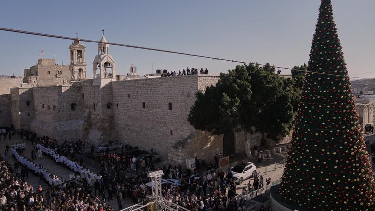 Katholische Geistliche ziehen am Heiligabend in einer Prozession neben der Geburtskirche.