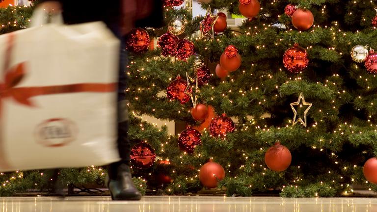 Eine Frau geht in einem Berliner Einkaufszentrum an einem Weihnachtsbaum vorbei. (Archiv)