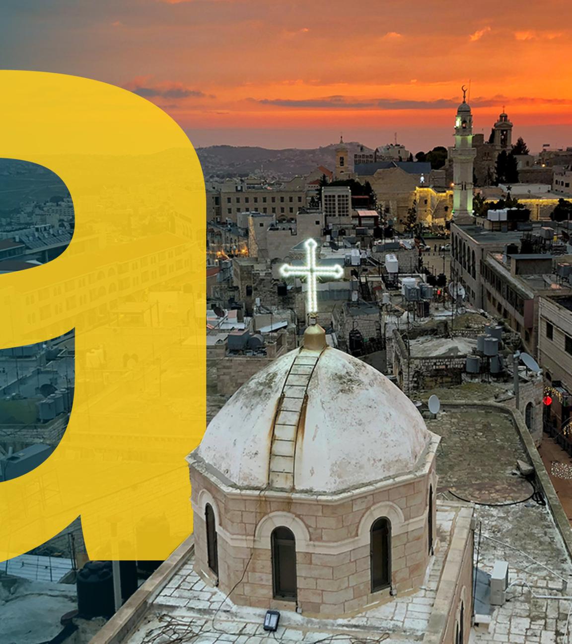 Blick aus der Vogelperspektive auf die Geburtskirche in Bethlehem, dahinter Sonnenuntergang und Gebäude der Stadt.