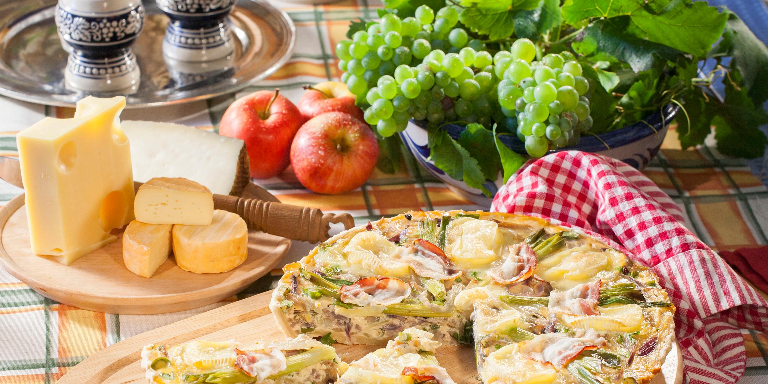 Weinkäse-Zwiebelkuchen auf einem Holzbrett angerichtet