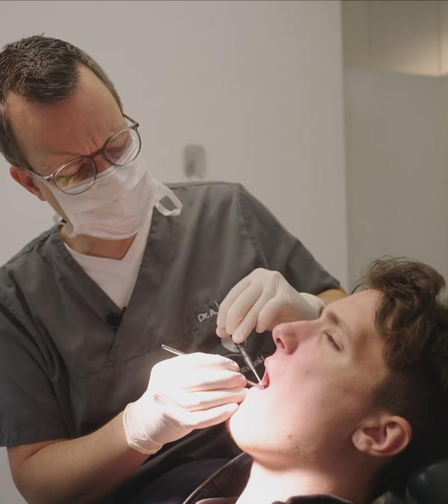 Das Bild zeigt einen Zahnarzt und seinen Patienten.