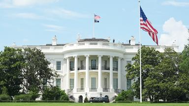 Weißes Haus in Washington mit USA-Flagge im Vordergrund
