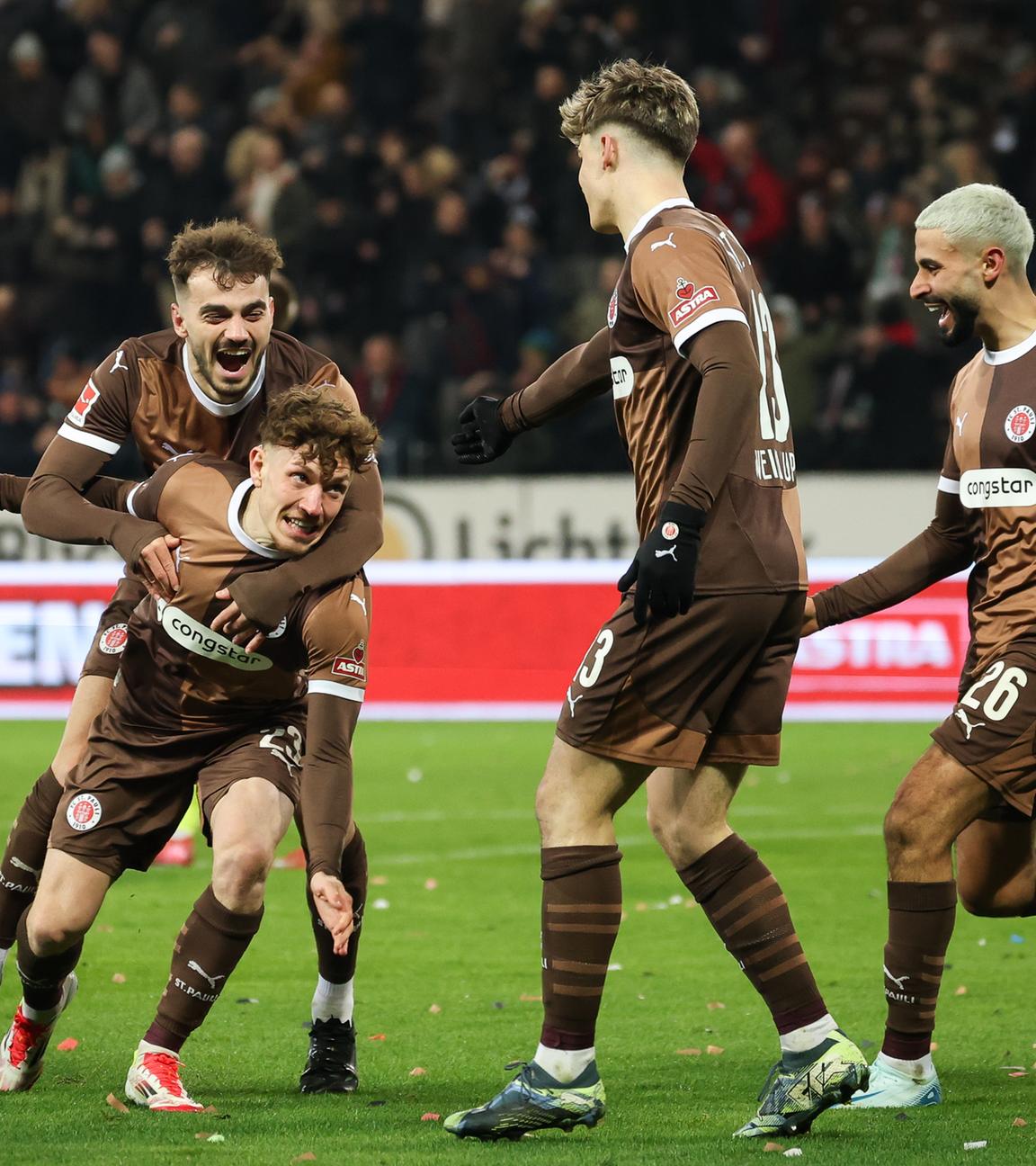 St. Paulis Noah Weißhaupt (2.v.r) feiert sein Tor zum 1:0 mit Daniel Sinani (l-r), Philipp Treu und Elias Saad.