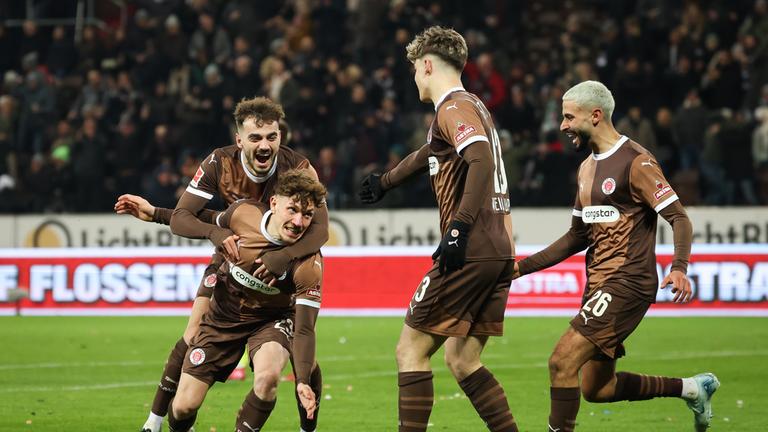 St. Paulis Noah Weißhaupt (2.v.r) feiert sein Tor zum 1:0 mit Daniel Sinani (l-r), Philipp Treu und Elias Saad.