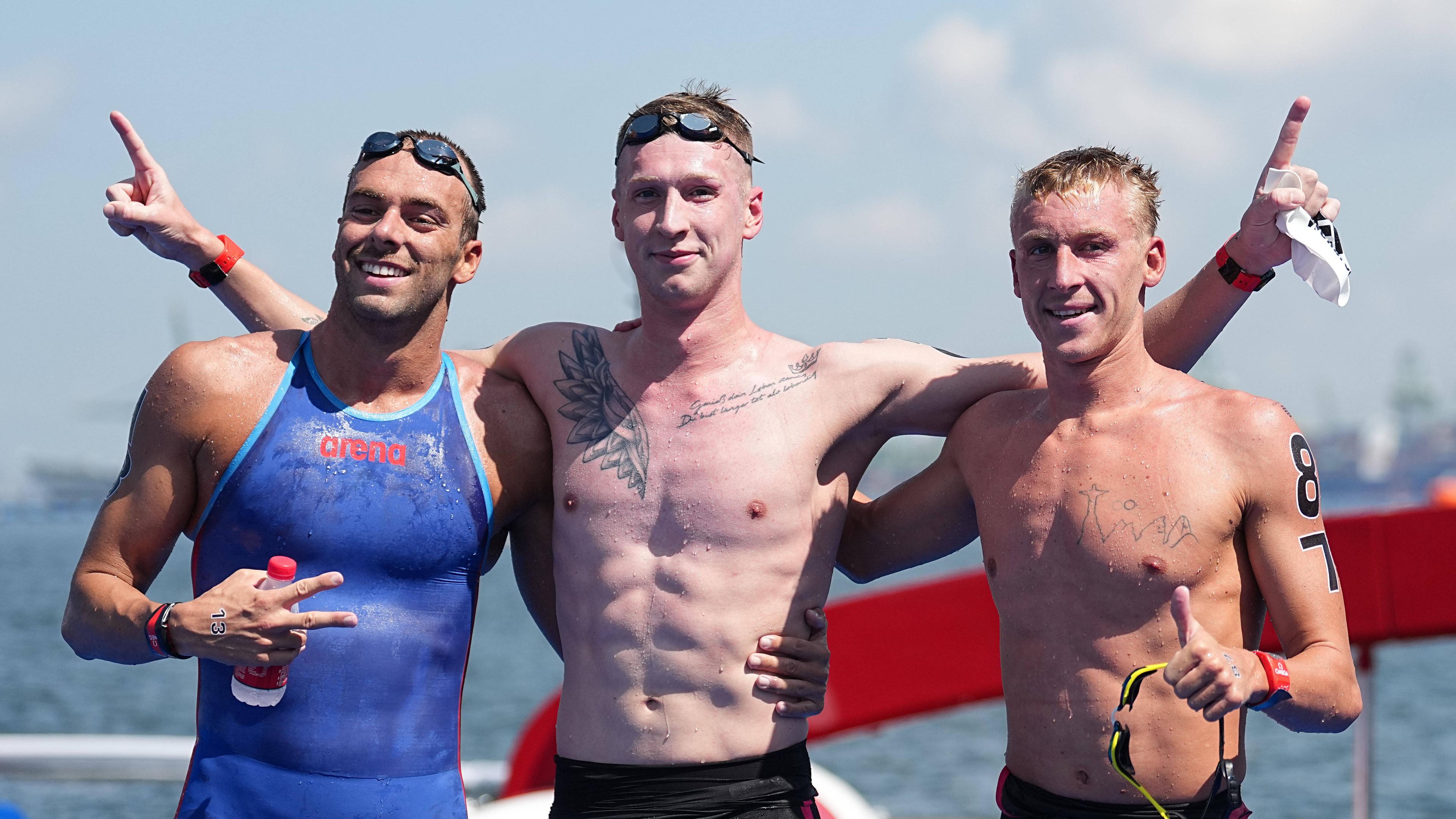 Florian Wellbrock (Mitte), Silbermedaillengewinner Gregorio Paltrinieri (links) und Marc-Antoine Olivier (Dritter) nach dem Rennen über 5 km