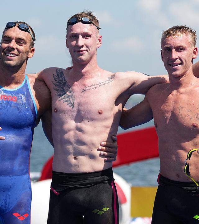 Florian Wellbrock (Mitte), Silbermedaillengewinner Gregorio Paltrinieri (links) und Marc-Antoine Olivier (Dritter) nach dem Rennen über 5 km