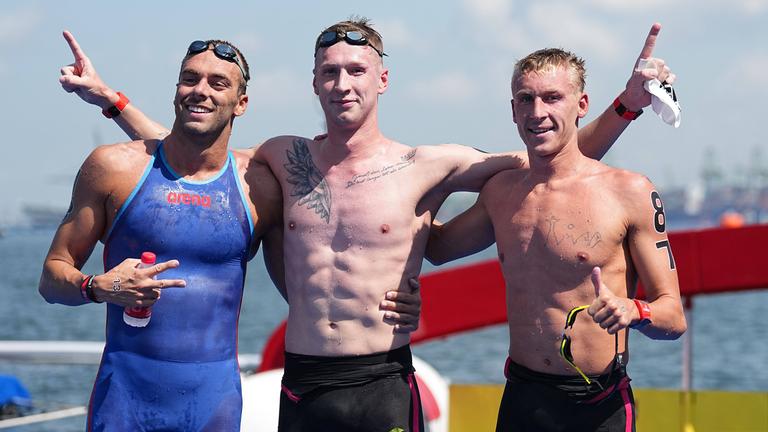Florian Wellbrock (Mitte), Silbermedaillengewinner Gregorio Paltrinieri (links) und Marc-Antoine Olivier (Dritter) nach dem Rennen über 5 km