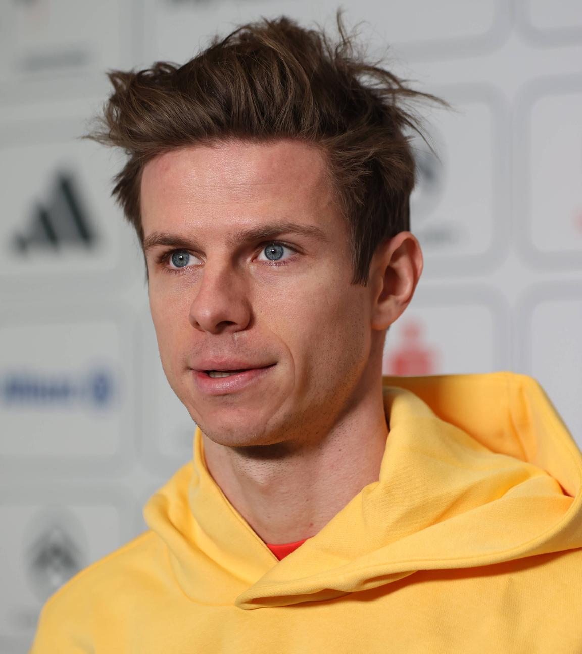 Olympiasieger Andreas Wellinger steht in gelbem Pullover in der Mixed-Zone