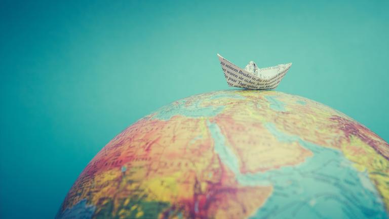 Papierboot auf einem Globus