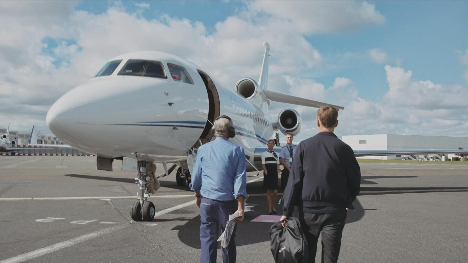 Zwei Männer gehen auf einen Privatjet zu
