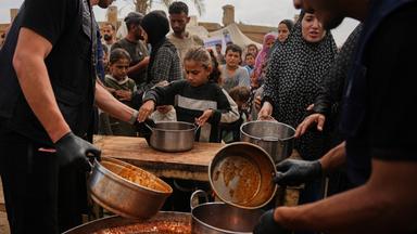 Palästinensische Gebiete, Deir al-Balah: Palästinenser erhalten in einem Flüchtlingslager in Deir al-Balah im zentralen Gazastreifen vom Welternährungsprogramm gespendete Lebensmittel.