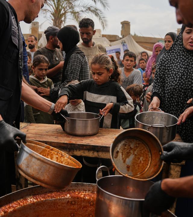 Palästinensische Gebiete, Deir al-Balah: Palästinenser erhalten in einem Flüchtlingslager in Deir al-Balah im zentralen Gazastreifen vom Welternährungsprogramm gespendete Lebensmittel.