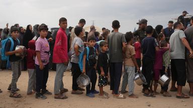 Palästinensische Gebiete, Deir al-Balah: Palästinenser stehen in einem Flüchtlingslager in Deir al-Balah im zentralen Gazastreifen Schlange, um vom Welternährungsprogramm gespendete Lebensmittel zu erhalten.