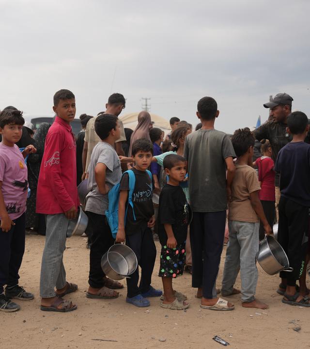 Palästinensische Gebiete, Deir al-Balah: Palästinenser stehen in einem Flüchtlingslager in Deir al-Balah im zentralen Gazastreifen Schlange, um vom Welternährungsprogramm gespendete Lebensmittel zu erhalten.