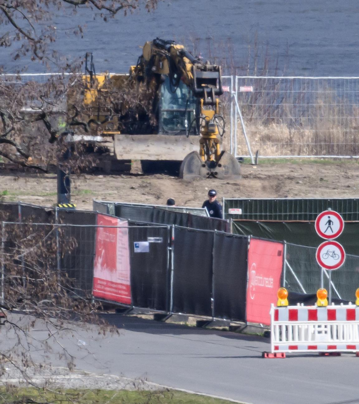 Mitarbeiter der Kampfmittelbeseitigung stehen auf der Baustelle an der abgerissenen Carolabrücke an der Fundstelle der Bombe.