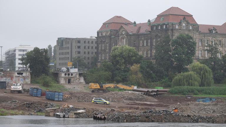 Sachsen, Dresden: Ein Polizeifahrzeug steht auf der Baustelle an der abgerissenen Carolabrücke auf der Neustädter Elbseite vor der Sächsischen Staatskanzlei.