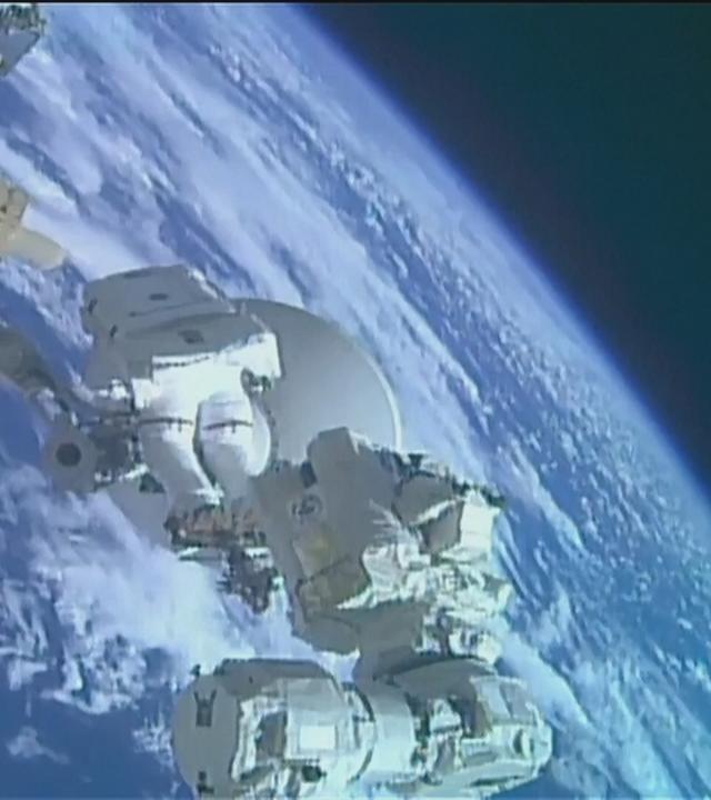 Zwei Astronat*innen installieren eine Hochgeschwindigkeitsantenne