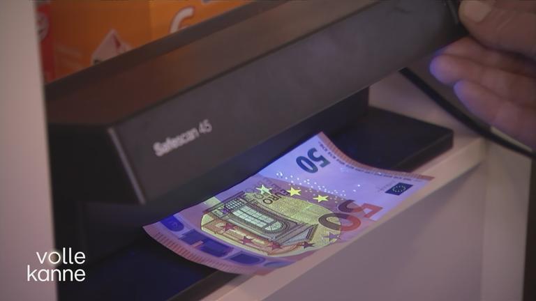 50-Euro-Schein wird auf Echtheit im Automatem geprüft.