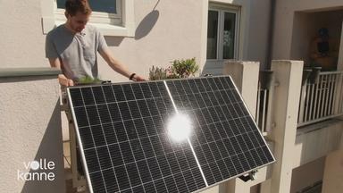 Mann begutachtet PV-Anlage am Balkon