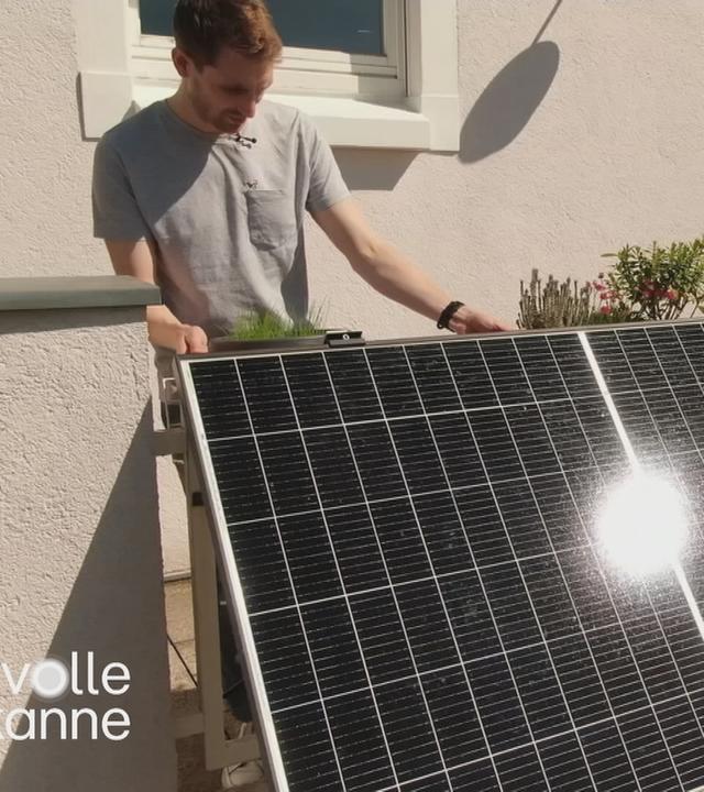 Mann begutachtet PV-Anlage am Balkon