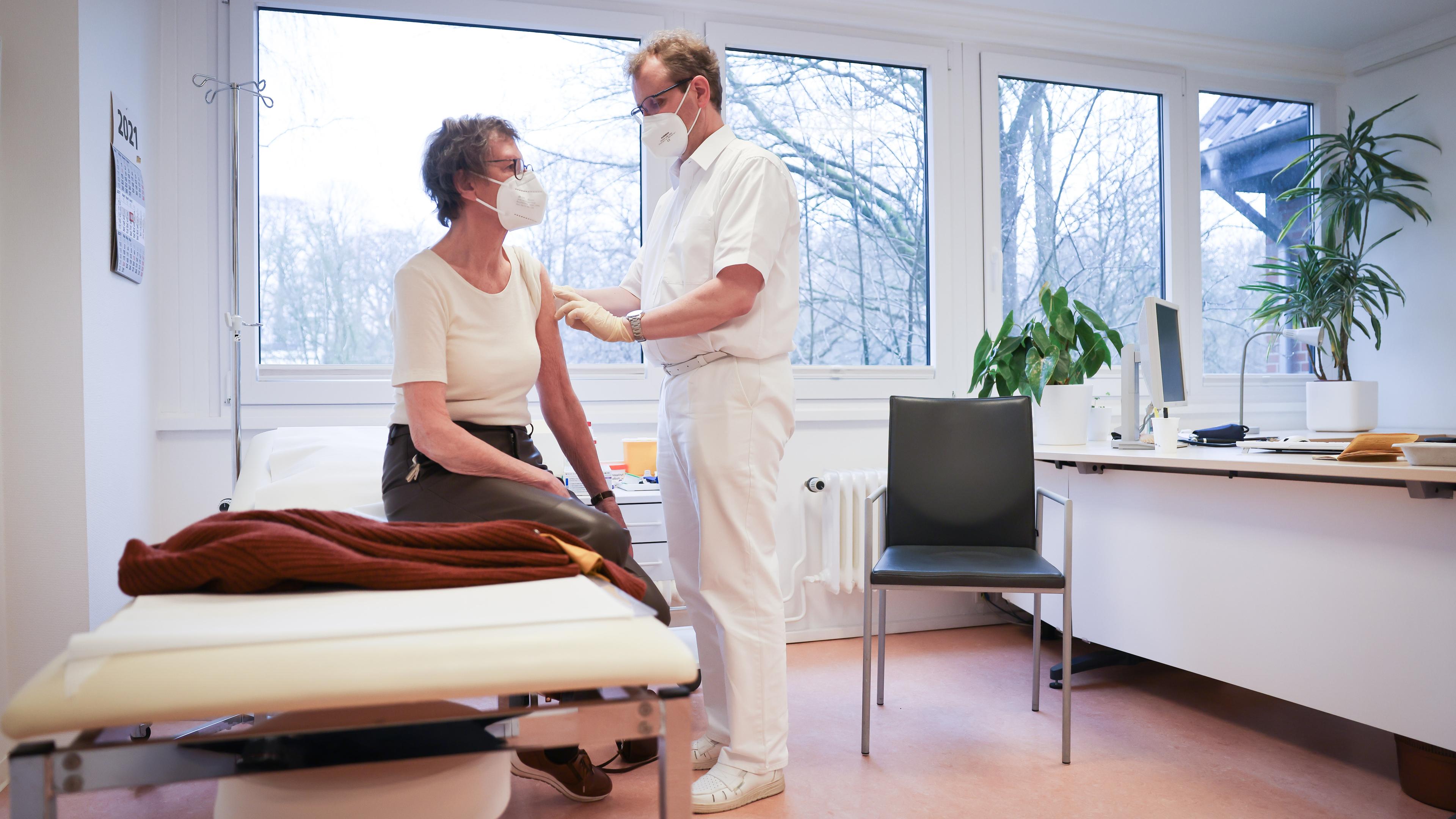 Björn Parey, Allgemeinmediziner, impft seine Patientin Christa Janssen mit dem Corona-Impfstoff von Biontech/Pfizer in seiner Praxis für Allgemeinmedizin in Hamburg-Volksdorf.