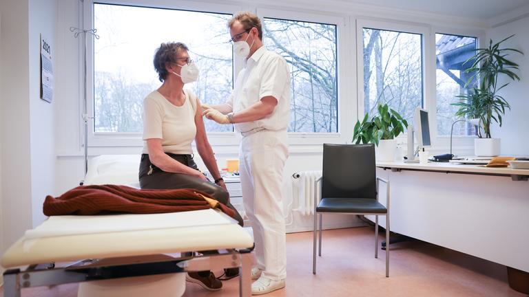 Björn Parey, Allgemeinmediziner, impft seine Patientin Christa Janssen mit dem Corona-Impfstoff von Biontech/Pfizer in seiner Praxis für Allgemeinmedizin in Hamburg-Volksdorf.