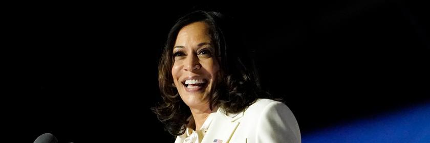 Kamala Harris steht an einem Rednerpult. Sie lächelt. 