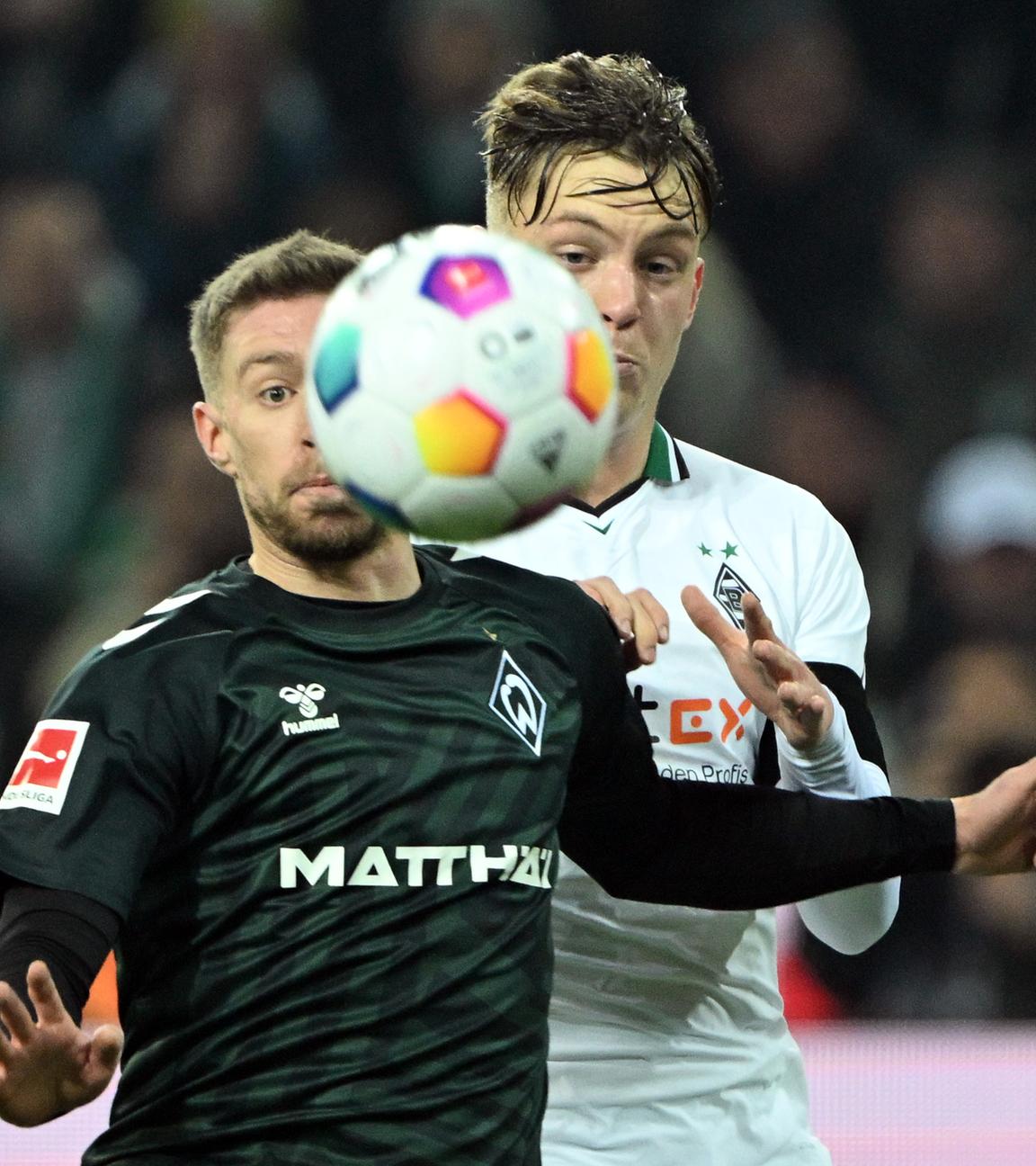 Werder Bremens Mitchell Weiser (l.) und Luca Netz (Mönchengladbach) am 15.12.2023 im Zweikampf