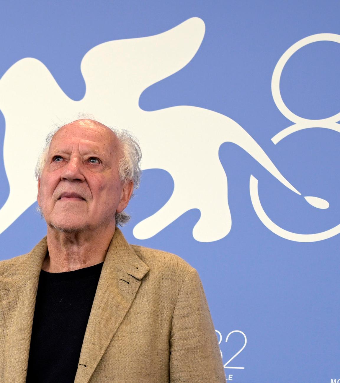 Werner Herzog bei den Filmfestspielen in Venedig. Hinter ihm steht eine große 82 an der Wand, da es die 82. Filmfestspiele sind