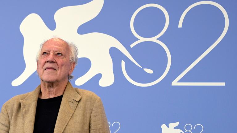 Werner Herzog bei den Filmfestspielen in Venedig. Hinter ihm steht eine große 82 an der Wand, da es die 82. Filmfestspiele sind