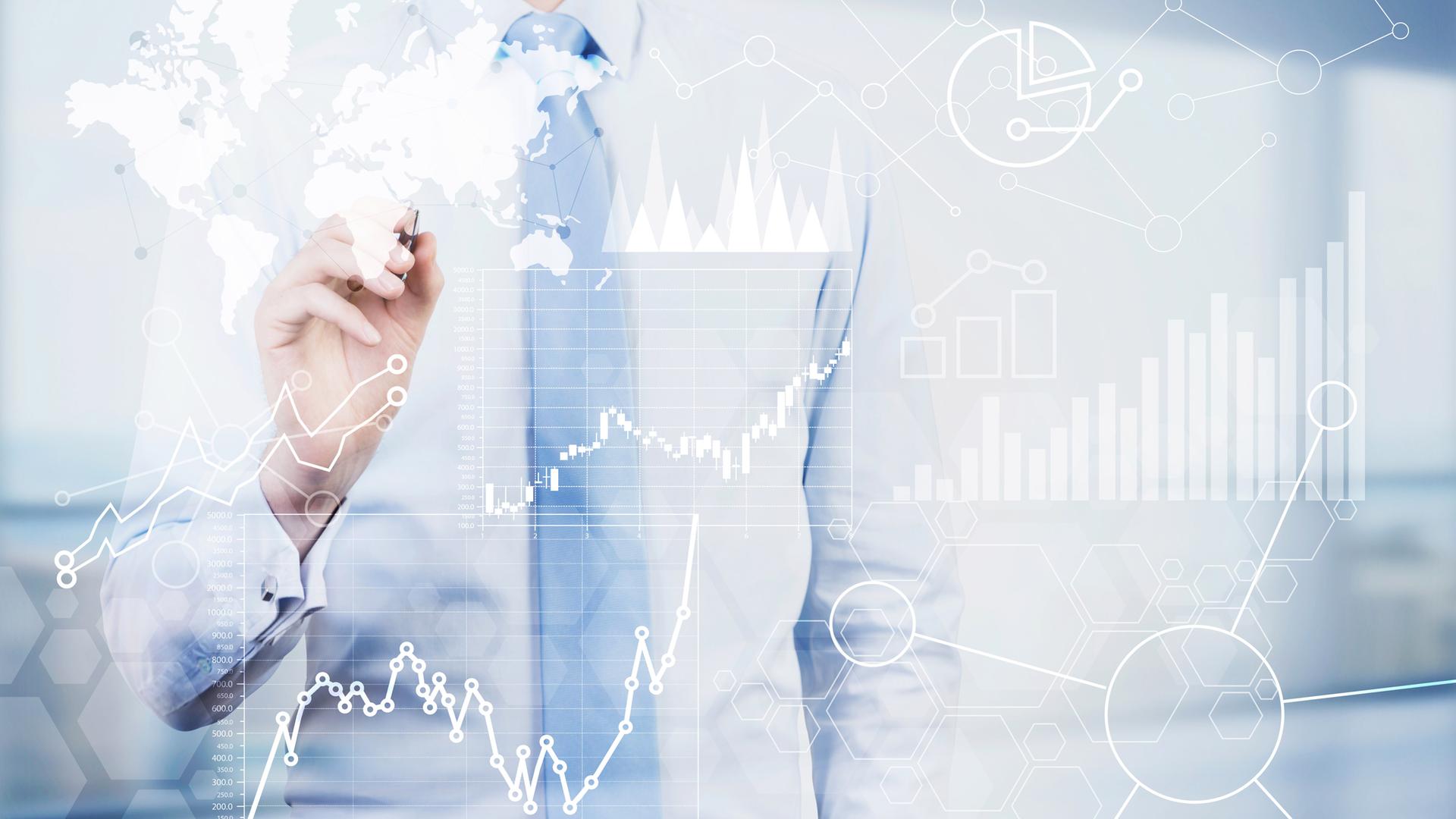 Im Vordergrund Finanztabellen. Im Hintergrund der Oberkörper eines Mannes im Hemd, der die Hand zum Zeichnen hebt.