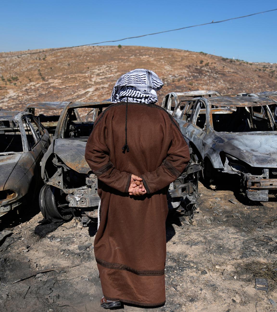 Palestinian landlord Saber Asaleyeh, 74, inspects his scrapyard where vehicles were scorched during an Israeli settler attack overnight, residents said, in the West Bank village of Burqa, east of Ramallah Tuesday, July 15, 2025.