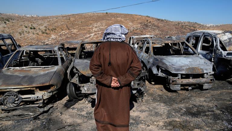 Palestinian landlord Saber Asaleyeh, 74, inspects his scrapyard where vehicles were scorched during an Israeli settler attack overnight, residents said, in the West Bank village of Burqa, east of Ramallah Tuesday, July 15, 2025.