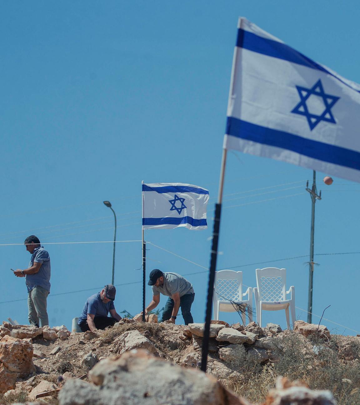 Siedler hissen Fahnen in Bruqin: Jüdische Siedler hissen am 23. Mai 2025 israelische Flaggen auf palästinensischen Häusern im Dorf Bruqin im nördlichen Westjordanland.