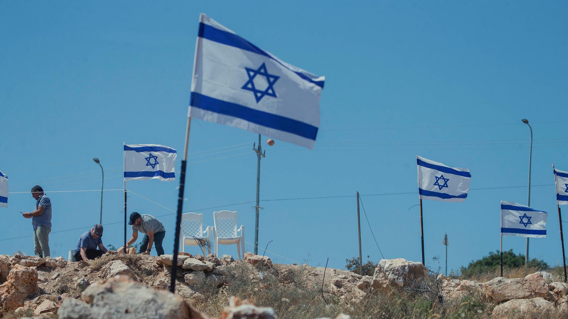 Siedler hissen Fahnen in Bruqin: Jüdische Siedler hissen am 23. Mai 2025 israelische Flaggen auf palästinensischen Häusern im Dorf Bruqin im nördlichen Westjordanland.