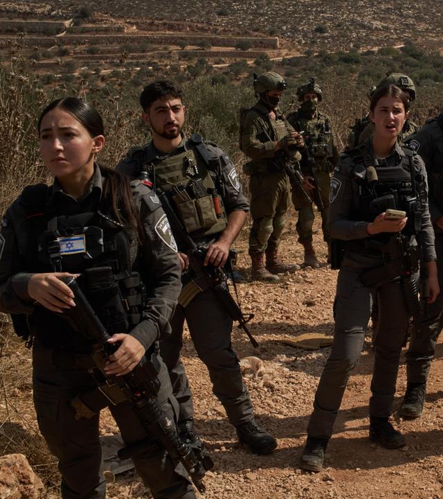 Angehörige der israelischen Streitkräfte sperren eine Straße ab und hindern Palästinenser daran, die Olivenhaine zu erreichen.