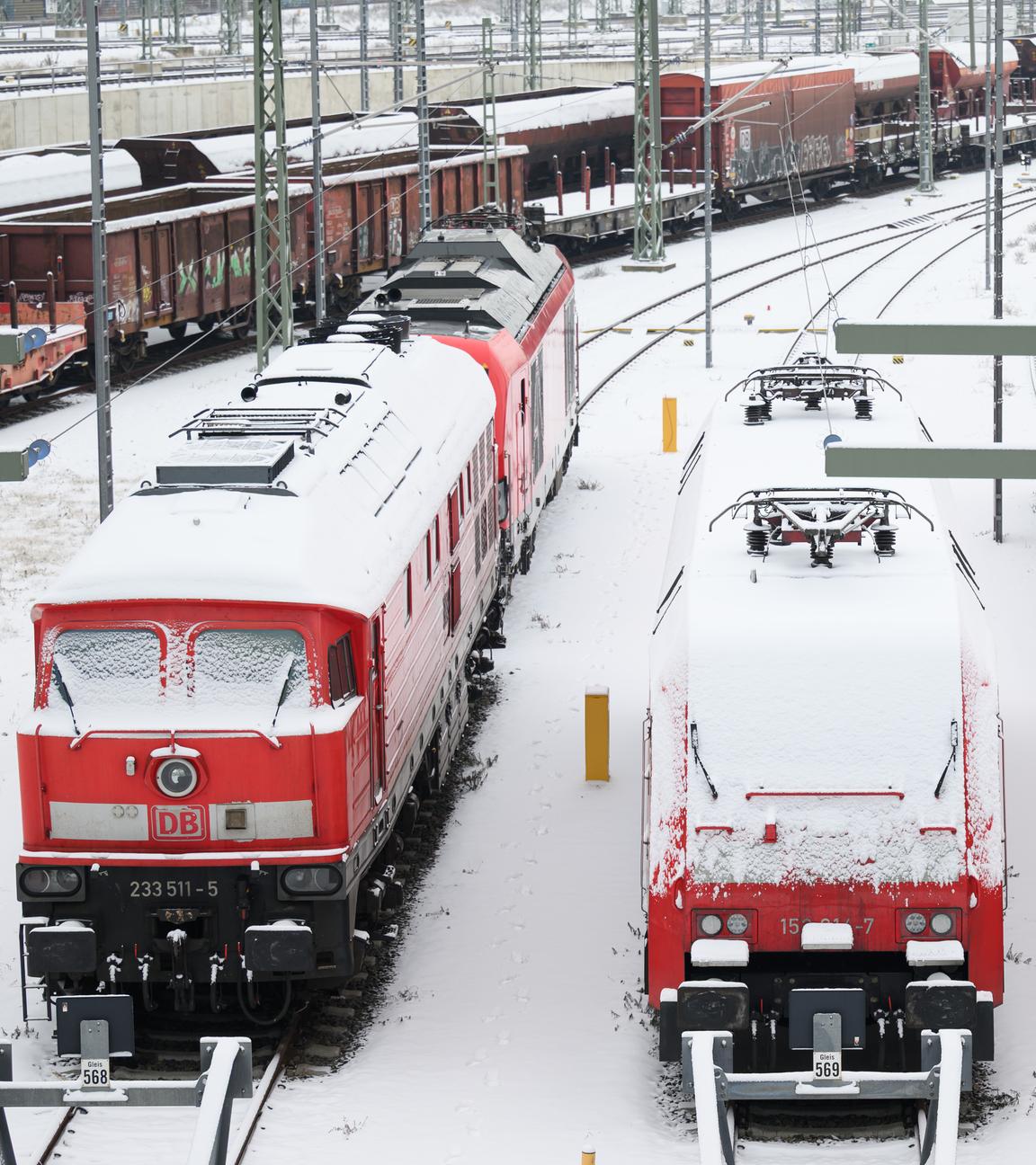 Lokomotiven im Bahnhof, die von Schnee bedeckt sind.