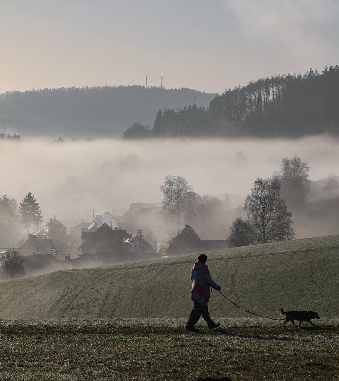 Eine Person geht, bei Nebel am Morgen, mit ihrem Hund spazieren am 12.03.2026 in Siegen spazieren.