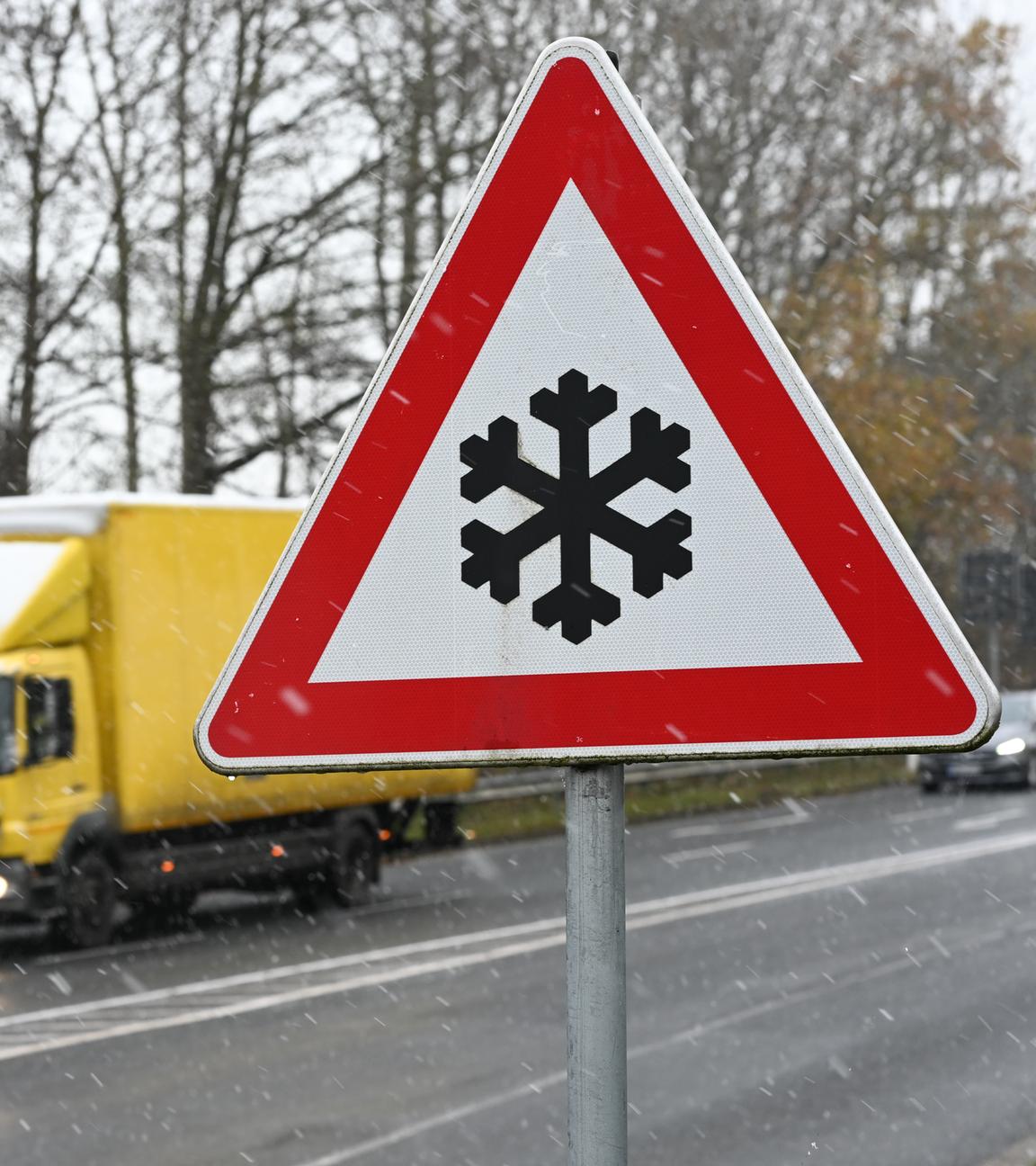  Ein Verkehrszeichen an einer Straße weist auf mögliche Glätte auf der Fahrbahn hin. Auch im Nordwesten Deutschlands herrscht winterliches Wetter.