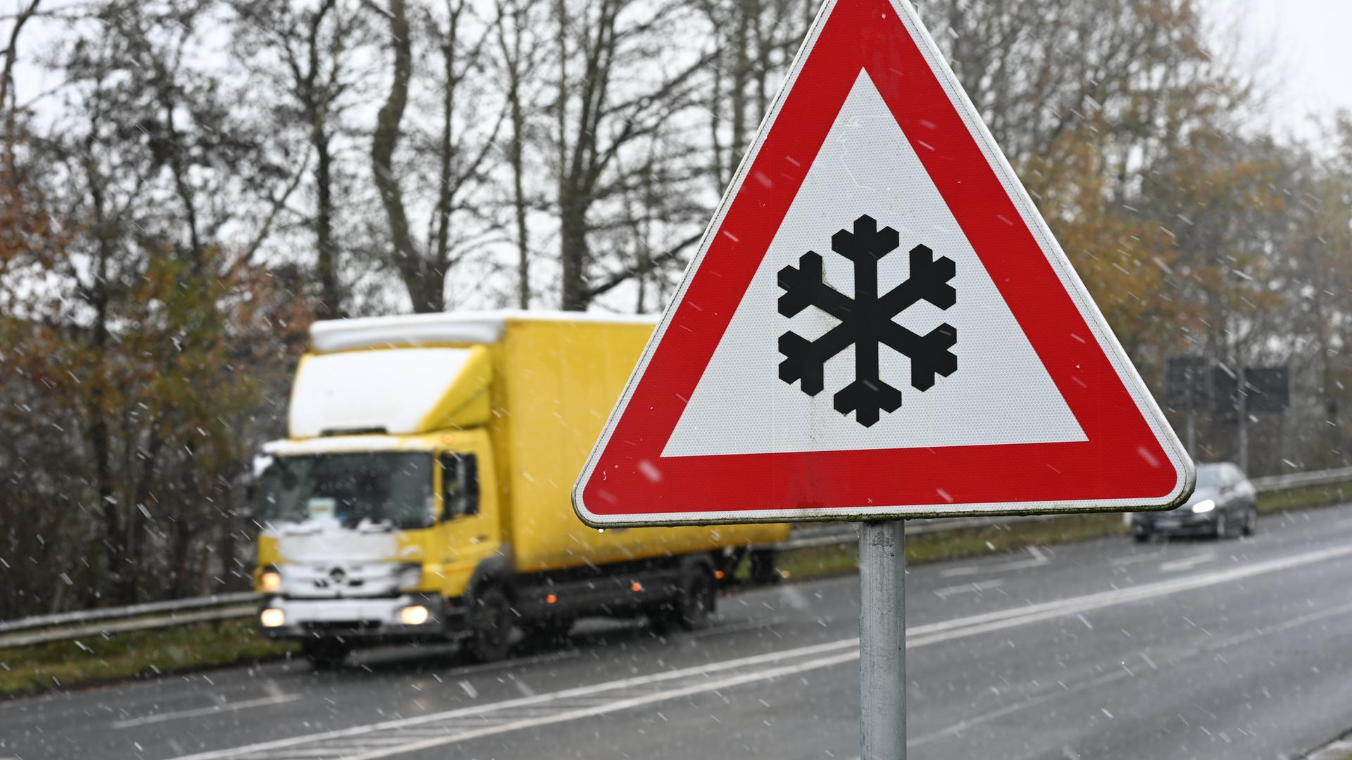  Ein Verkehrszeichen an einer Straße weist auf mögliche Glätte auf der Fahrbahn hin. Auch im Nordwesten Deutschlands herrscht winterliches Wetter.